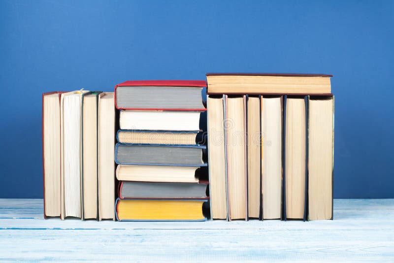Book stack, hardback colorful books on wooden table and blue background. Back to school. Copy space for text. Education stock photography Book stack, hardback colorful books on wooden table and blue background. Back to school. Copy space for text. Education stock photography