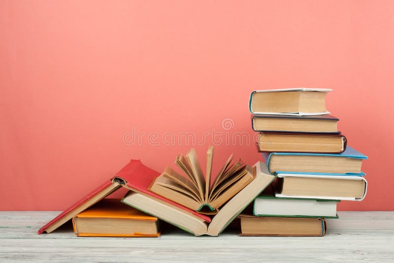 Book stacking. Open book, hardback books on wooden table and pink background. Back to school. Copy space for text stock images Book stacking. Open book, hardback books on wooden table and pink background. Back to school. Copy space for text stock images
