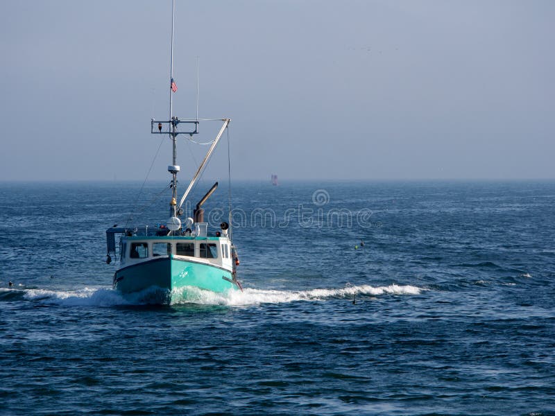 Fishing boat heading toward harbor with fog in background. Fishing boat heading toward harbor with fog in background