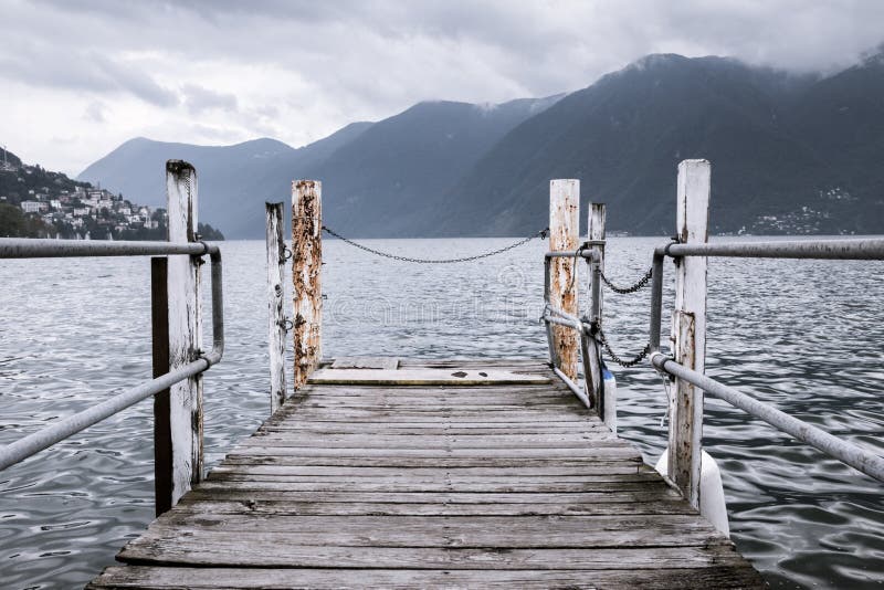 Boat dock in Lugano, Switzerland. Nautical, travel, European vacation, boating and yachting concept. High contrast. Vintage processed. Boat dock in Lugano, Switzerland. Nautical, travel, European vacation, boating and yachting concept. High contrast. Vintage processed