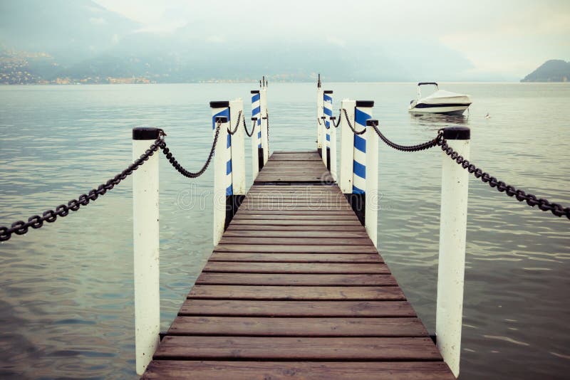 Boat dock in Menaggio, Lake Como, Italy. Nautical, travel, European vacation, boating and yachting concept. High contrast. Vintage processed. Boat dock in Menaggio, Lake Como, Italy. Nautical, travel, European vacation, boating and yachting concept. High contrast. Vintage processed