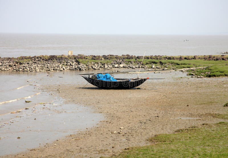 Boote von den Fischern bei Ebbe angeschwemmt im Schlamm auf der Küste des Golfs von Bengalen stockfotografie Boote von den Fischern bei Ebbe angeschwemmt im Schlamm auf der Küste des Golfs von Bengalen stockfotografie