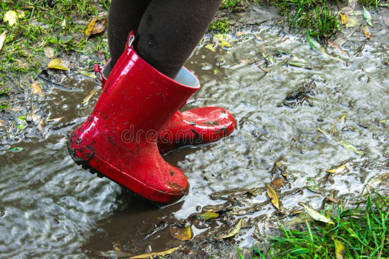 Child Wearing Red Rain Boots Jumping into a Puddle Stock Photo - Image ...