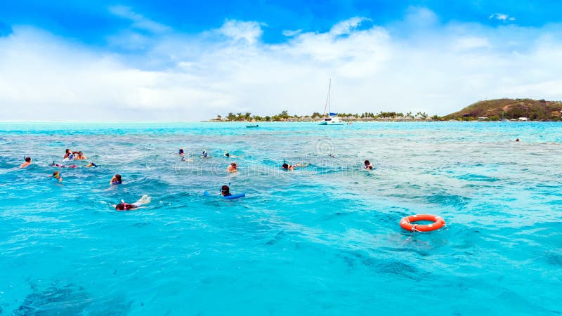 BORA BORA, FRENCH POLYNESIA - SEPTEMBER 19, 2018: People swim in the ocean with masks. Copy space for text royalty free stock image BORA BORA, FRENCH POLYNESIA - SEPTEMBER 19, 2018: People swim in the ocean with masks. Copy space for text royalty free stock image