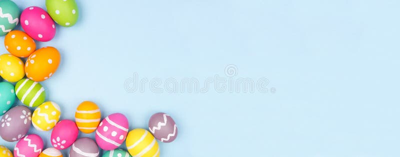 Borda colorida do canto do ovo da Páscoa sobre um fundo de banner azul pastel