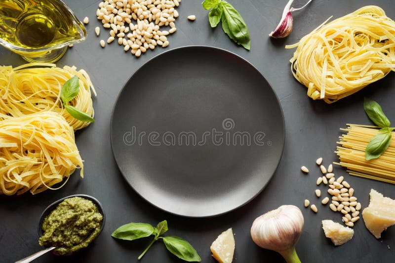 Border of raw pasta durum wheat, pesto, basil, parmesan for cooking Mediterranean dishes. Top view, space for text