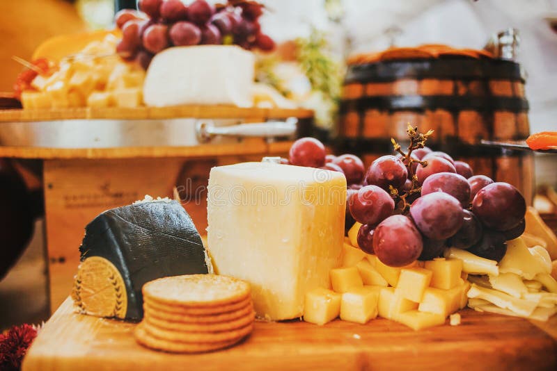 Bordo del formaggio ed uva, salame e cracker, su un fondo di legno e rustico a Messico City immagine stock libera da diritti Bordo del formaggio ed uva, salame e cracker, su un fondo di legno e rustico a Messico City immagine stock libera da diritti