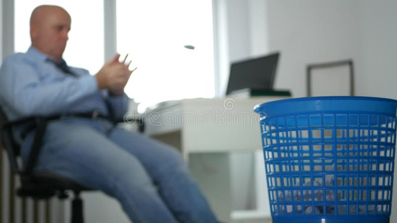 Bored businessman image in office throwing crumpled paper on trash basket