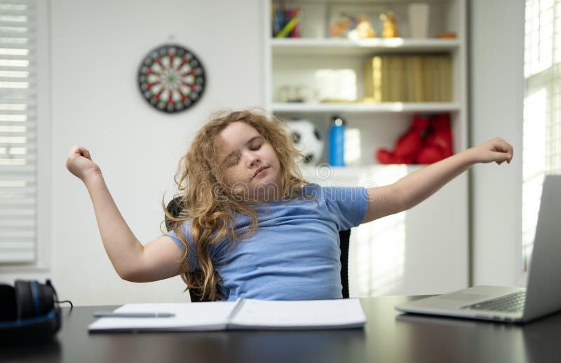 Bored kid leaning back tired of studying. Bored child waiting for study break. Bored kid sighing during long study hours. Child royalty free stock photos