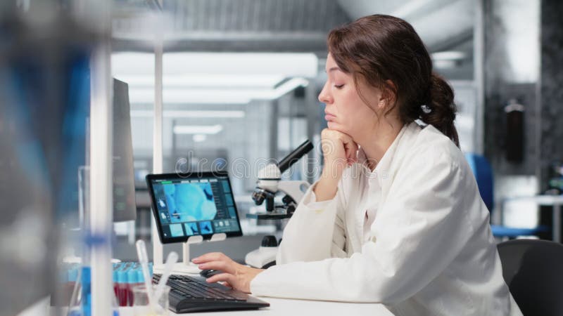 Bored medical laboratory technician using computer application stock footage