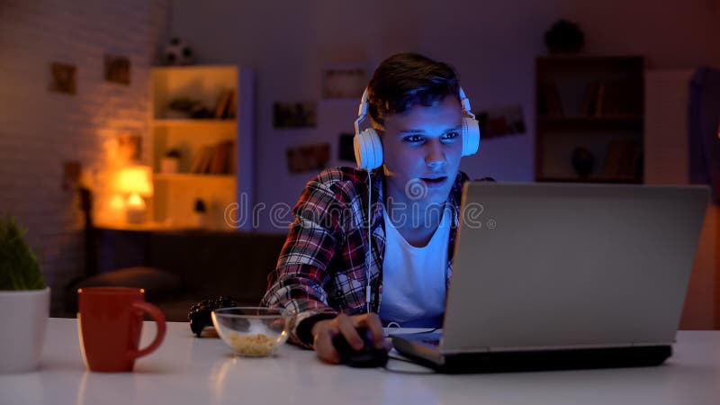 Bored teenager surfing internet, eating snacks and wasting time, procrastination royalty free stock photo Bored teenager surfing internet, eating snacks and wasting time, procrastination royalty free stock photo