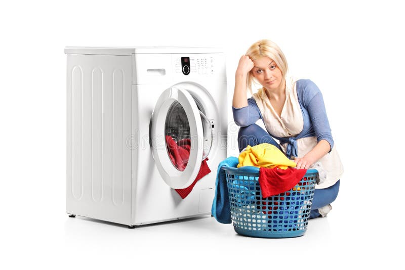 Bored woman sitting by a washing machine royalty free stock photography