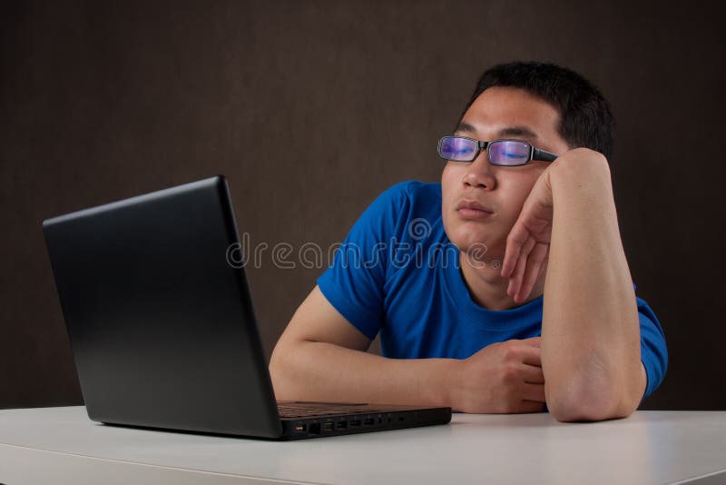 Bored young asian man working with his computer stock photo Bored young asian man working with his computer stock photo