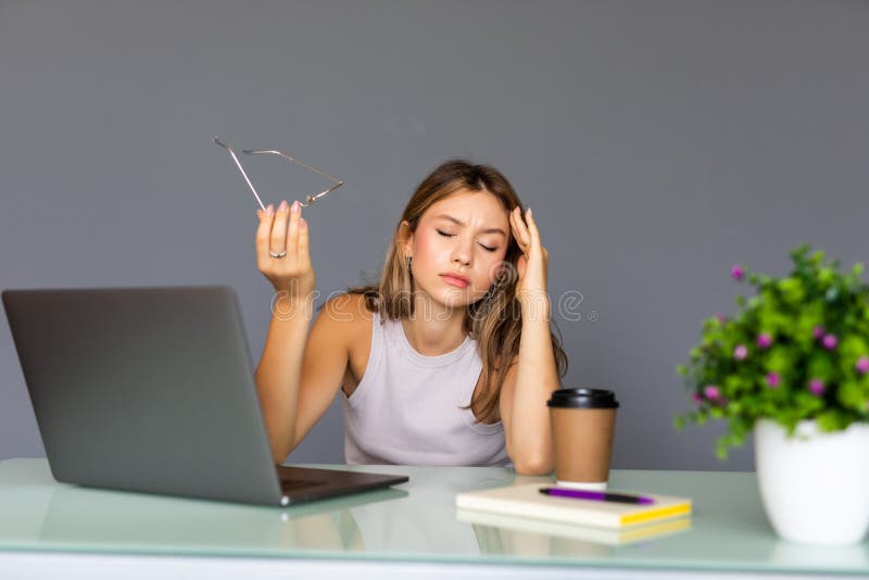Bored young woman in the office working with a laptop and staring at screen royalty free stock photos