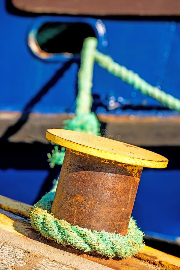 Borne avec la ligne d'amarrage et la coque bleue de bateau images stock Borne avec la ligne d'amarrage et la coque bleue de bateau images stock
