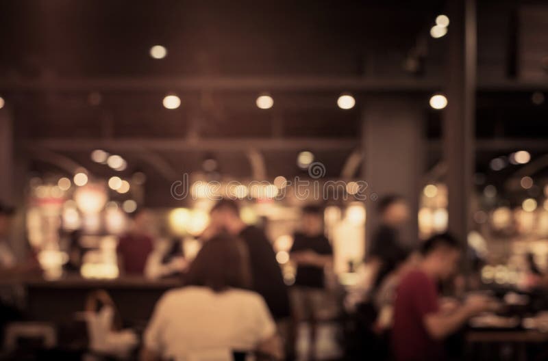 Borrão dos povos no café, restaurante com fundo da iluminação