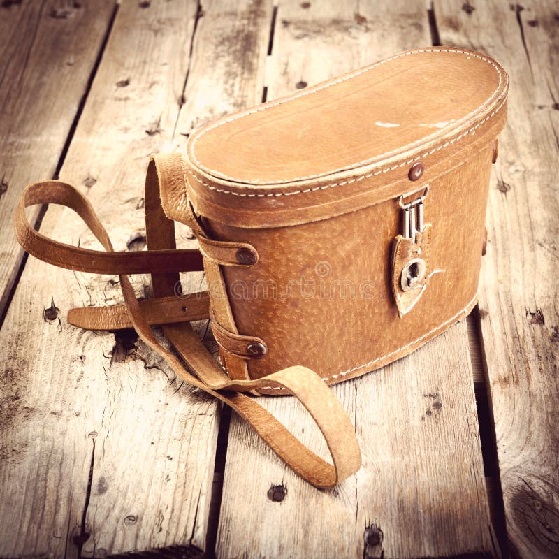 Old vintage leather bag with leather strap on wooden table filtered. Old vintage leather bag with leather strap on wooden table filtered