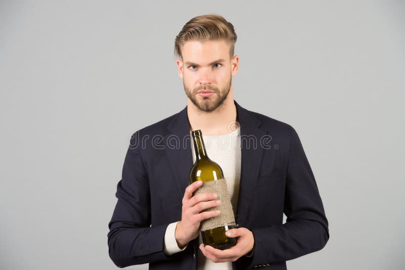 Boss with bottle of wine in hands. Bearded man hold alcoholic drink. Sommelier or degustator with wine. Alcohol addiction and bad royalty free stock image Boss with bottle of wine in hands. Bearded man hold alcoholic drink. Sommelier or degustator with wine. Alcohol addiction and bad royalty free stock image