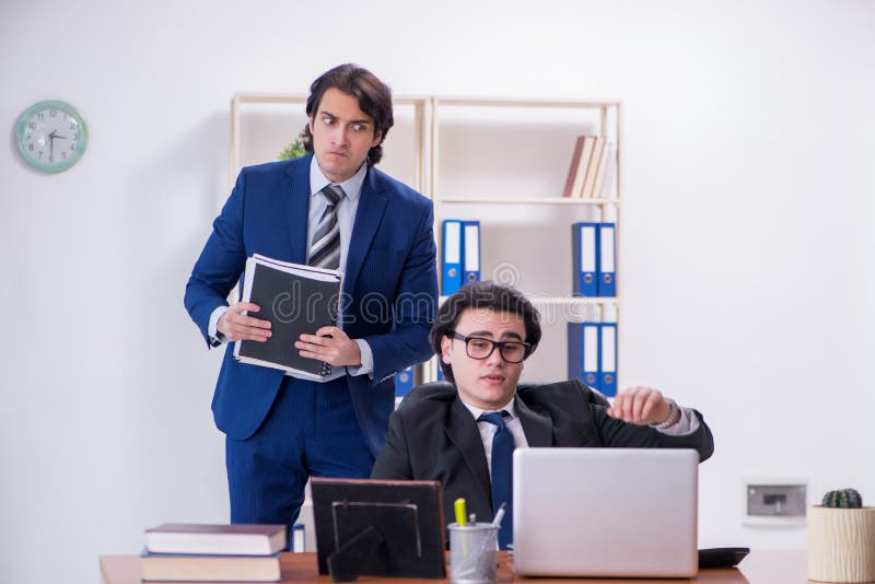 Boss and his male assistant working in the office stock photo