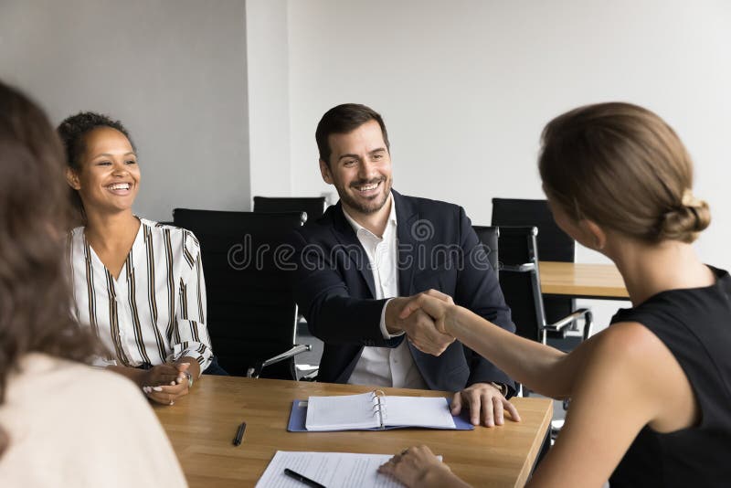 Boss shaking hands employee as acknowledgement of job well done stock photo