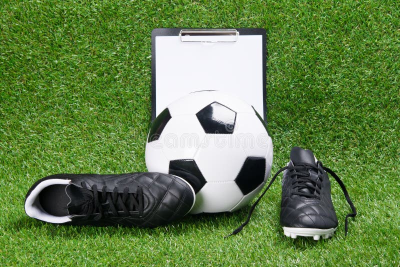 Botas, bola do futebol e tabuleta para escrever, na perspectiva da grama fotografia de stock Botas, bola do futebol e tabuleta para escrever, na perspectiva da grama fotografia de stock