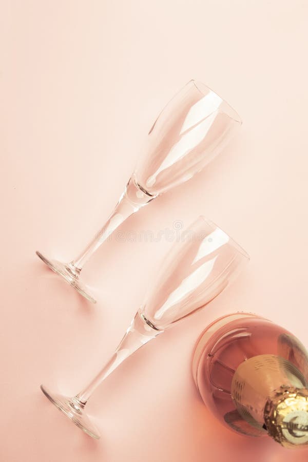 Botella con el vino espumoso rosado o champán color de rosa y dos vidrios, fondo rosado de moda con el lugar para el texto, día d fotos de archivo libres de regalías Botella con el vino espumoso rosado o champán color de rosa y dos vidrios, fondo rosado de moda con el lugar para el texto, día d fotos de archivo libres de regalías