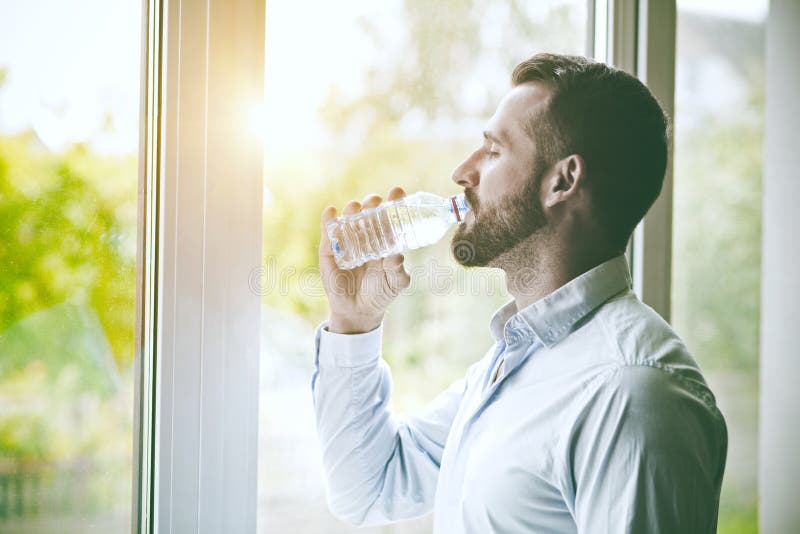 Hombre bebiendo una botella de agua foto de archivo libre de regalías