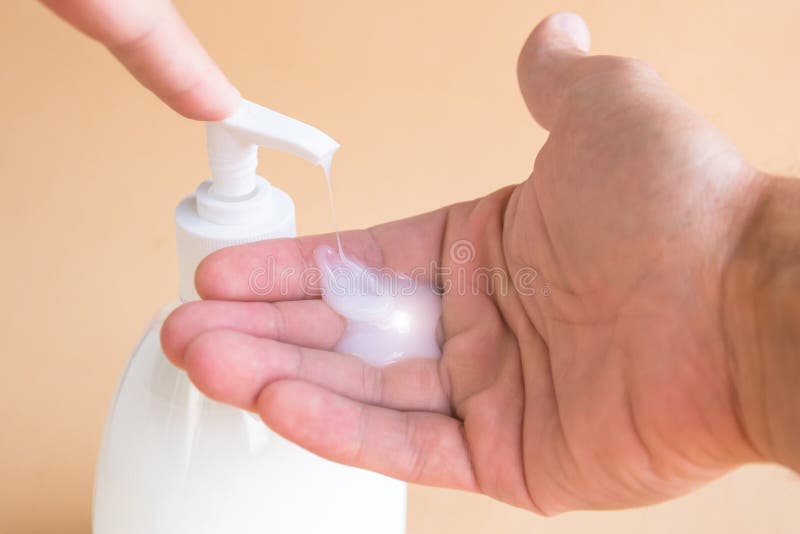 Botella del jabón líquido y el presionar en el dispensador, jabón en la palma Manos que se lavan