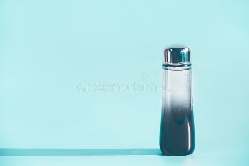 Botella líquida cosmética del producto con la esencia, la tinta o el aceite de limpiamiento en el fondo azul claro, vista delante imagenes de archivo Botella líquida cosmética del producto con la esencia, la tinta o el aceite de limpiamiento en el fondo azul claro, vista delante imagenes de archivo