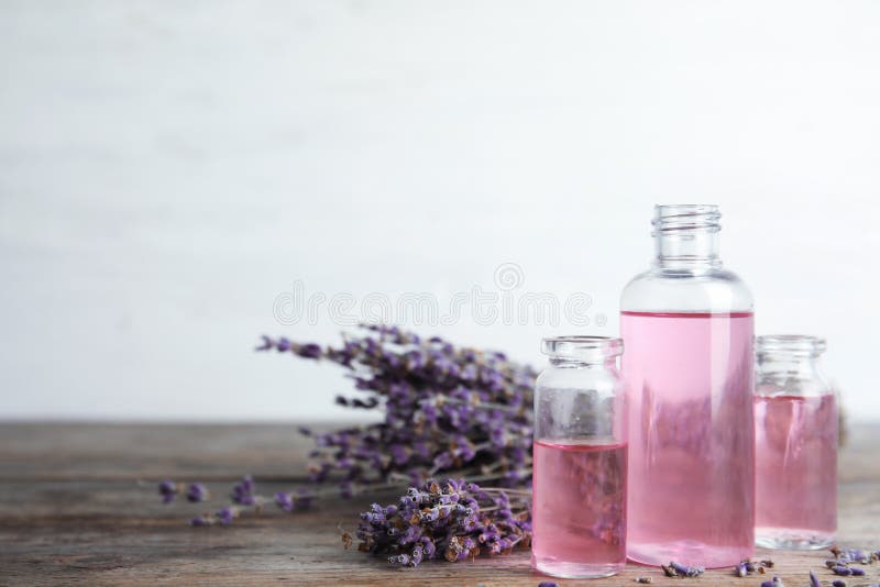 Botellas con aceite de lavanda aromático en la tabla de madera imagen de archivo Botellas con aceite de lavanda aromático en la tabla de madera imagen de archivo