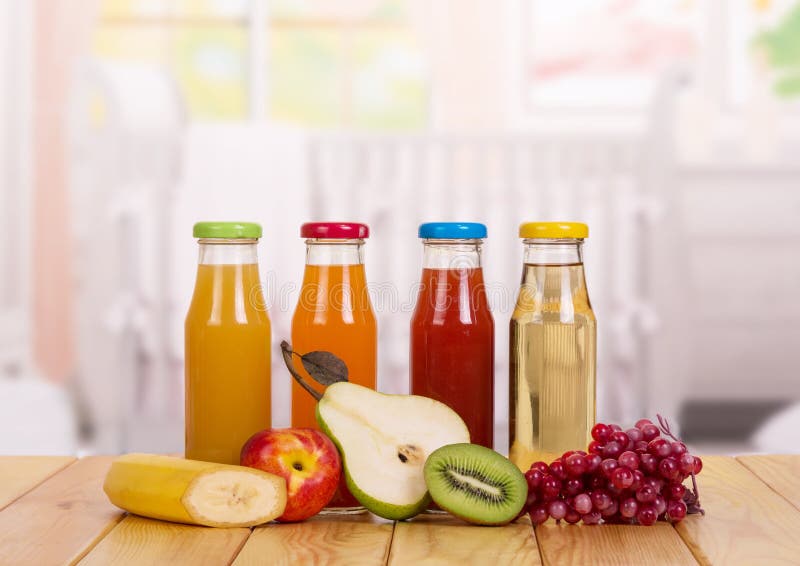 Botellas con las frutas frescas del jugo en cocina del fondo Alimentos para niños foto de archivo libre de regalías Botellas con las frutas frescas del jugo en cocina del fondo Alimentos para niños foto de archivo libre de regalías