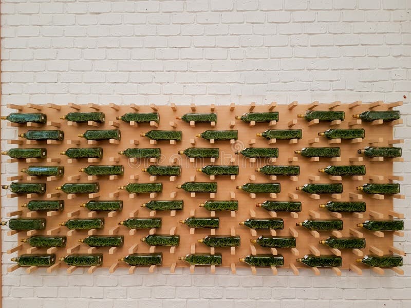 Botellas verdes en el tablero de madera y el fondo blanco de la pared de ladrillo imagen de archivo libre de regalías Botellas verdes en el tablero de madera y el fondo blanco de la pared de ladrillo imagen de archivo libre de regalías