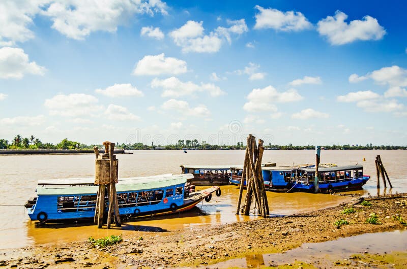 Botes basura atracados en franjas de madera en un río en el delta del mekong en vietnam ho chi minh city vietnam 2012020 editorial