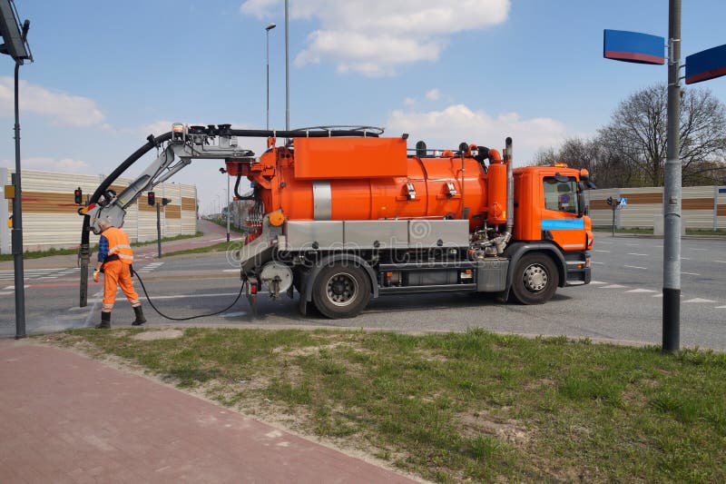 Botole di pulizia della fogna Automobile dello specialista e del lavoratore fotografia stock libera da diritti Botole di pulizia della fogna Automobile dello specialista e del lavoratore fotografia stock libera da diritti
