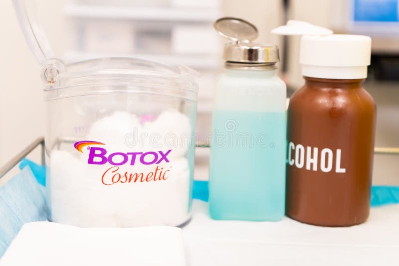 Botox Logo cosmetico su un contenitore pieno di palle di cotone, accanto a un strofinamento di alcol, in un ufficio medico steril
