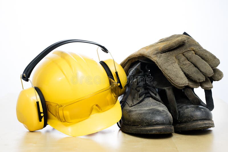Bottes de casque de protection et de travail sur une table en bois Sécurité et h images libres de droits Bottes de casque de protection et de travail sur une table en bois Sécurité et h images libres de droits