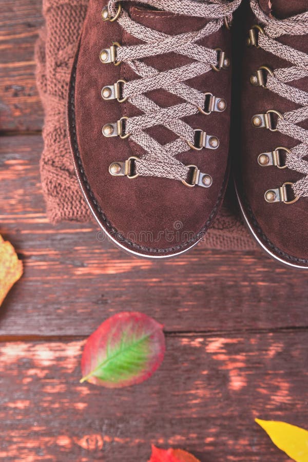 Bottes de suède d'homme de Brown avec le chandail sur le fond en bois image libre de droits Bottes de suède d'homme de Brown avec le chandail sur le fond en bois image libre de droits