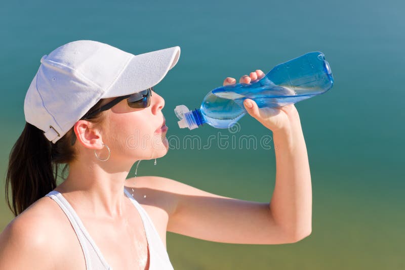 Bottiglia di acqua adatta della bevanda della donna di sport di estate fotografia stock libera da diritti Bottiglia di acqua adatta della bevanda della donna di sport di estate fotografia stock libera da diritti