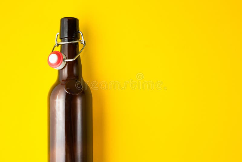 Bottiglia di birra marrone d'annata isolata su un fondo giallo Spazio per testo immagini stock libere da diritti Bottiglia di birra marrone d'annata isolata su un fondo giallo Spazio per testo immagini stock libere da diritti