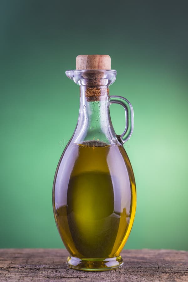 Bottiglia di olio d'oliva con il fondo verde del riflettore fotografie stock libere da diritti Bottiglia di olio d'oliva con il fondo verde del riflettore fotografie stock libere da diritti