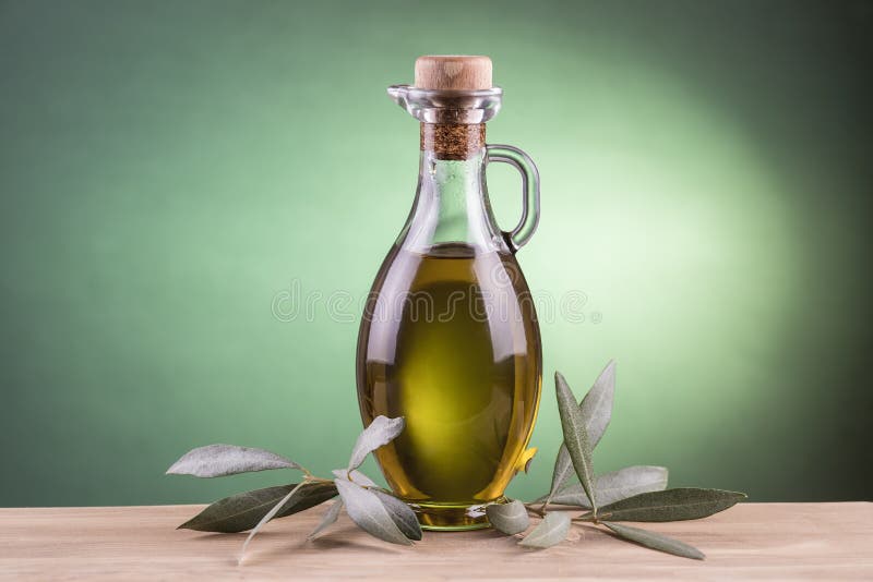 Bottiglia di olio d'oliva con il fondo verde del riflettore immagini stock libere da diritti Bottiglia di olio d'oliva con il fondo verde del riflettore immagini stock libere da diritti
