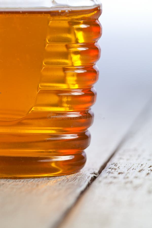 Bottiglia di plastica del barattolo con miele naturale organico e su fondo bianco immagini stock Bottiglia di plastica del barattolo con miele naturale organico e su fondo bianco immagini stock