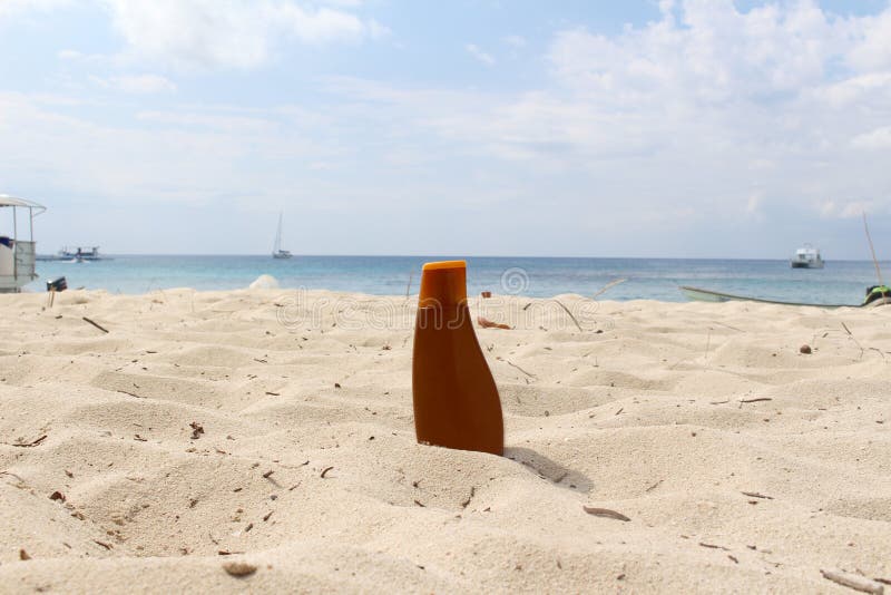 Bottiglia di Sunblock alla spiaggia fotografia stock