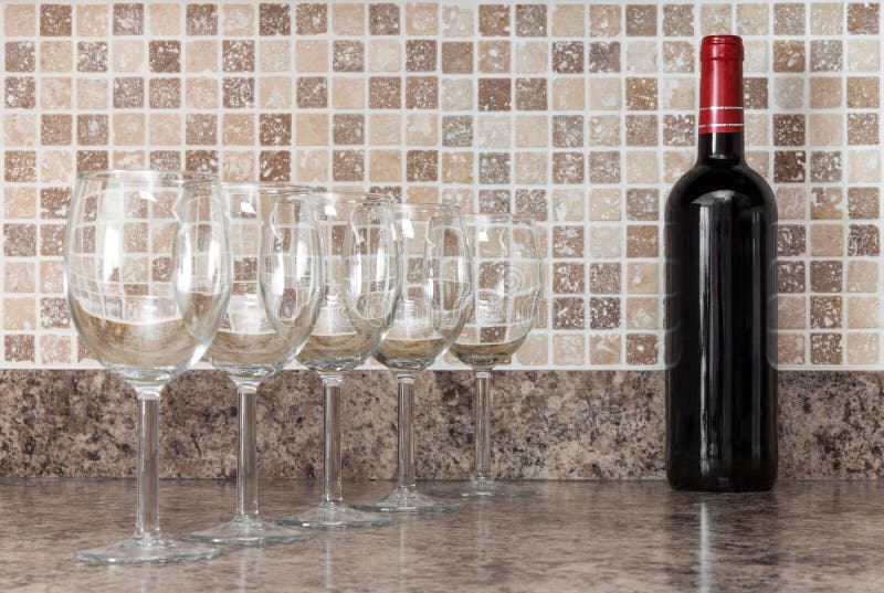 Bottiglia di vino e di vetri sul controsoffitto della cucina immagine stock libera da diritti Bottiglia di vino e di vetri sul controsoffitto della cucina immagine stock libera da diritti