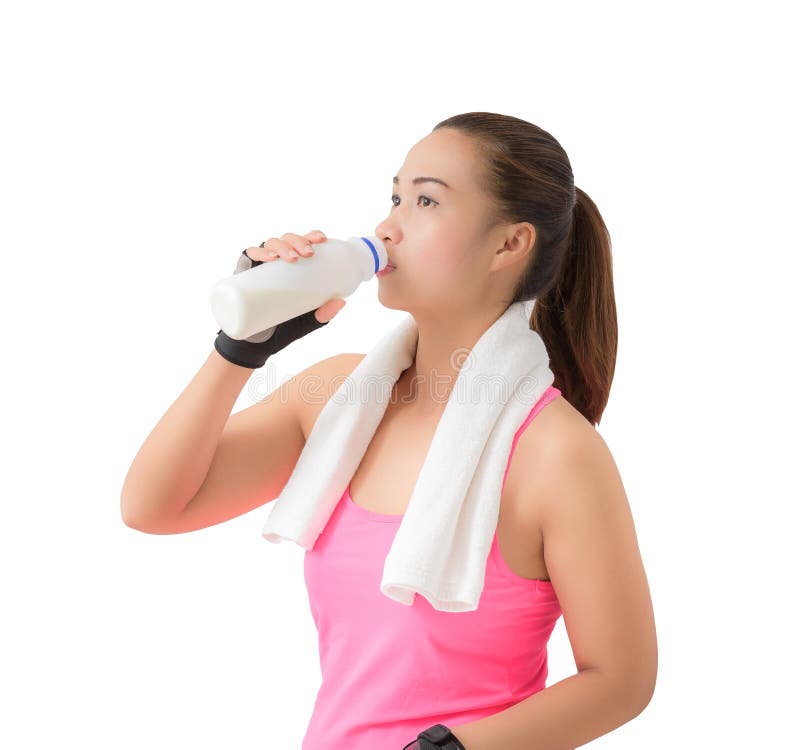 Bottiglia per il latte sorridente felice della tenuta della donna di forma fisica e mil bevente fotografia stock libera da diritti Bottiglia per il latte sorridente felice della tenuta della donna di forma fisica e mil bevente fotografia stock libera da diritti