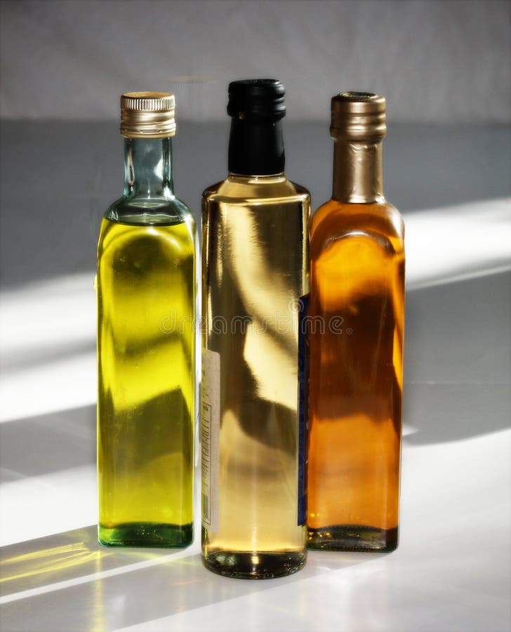 Glass bottles filled with olive and chili oil and white vinegar. Glass bottles filled with olive and chili oil and white vinegar.