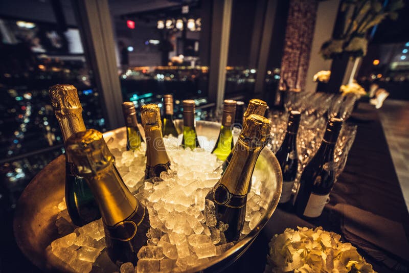 Bottiglie di vino di Champagne su ghiaccio sulla tavola d'approvvigionamento sull'evento di lusso della città fotografia stock libera da diritti Bottiglie di vino di Champagne su ghiaccio sulla tavola d'approvvigionamento sull'evento di lusso della città fotografia stock libera da diritti