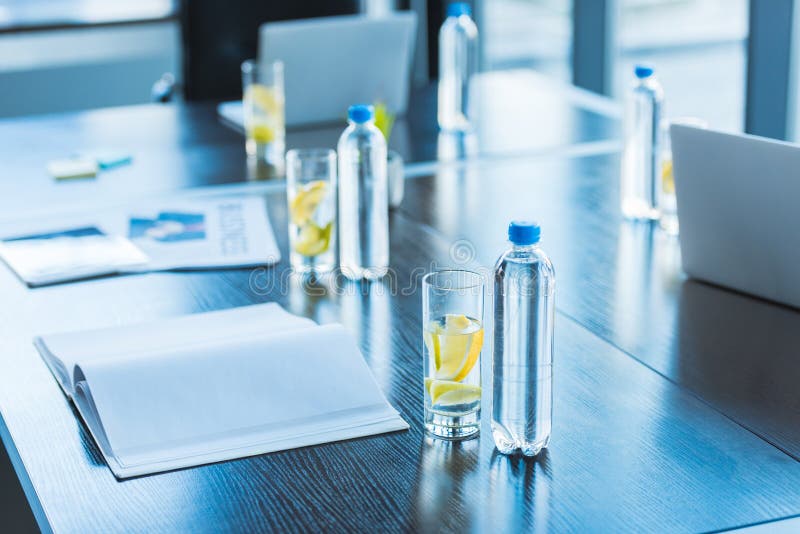 bottiglie e vetri con la bevanda antiossidante per la riunione d'affari sulla tavola nell'area di lavoro