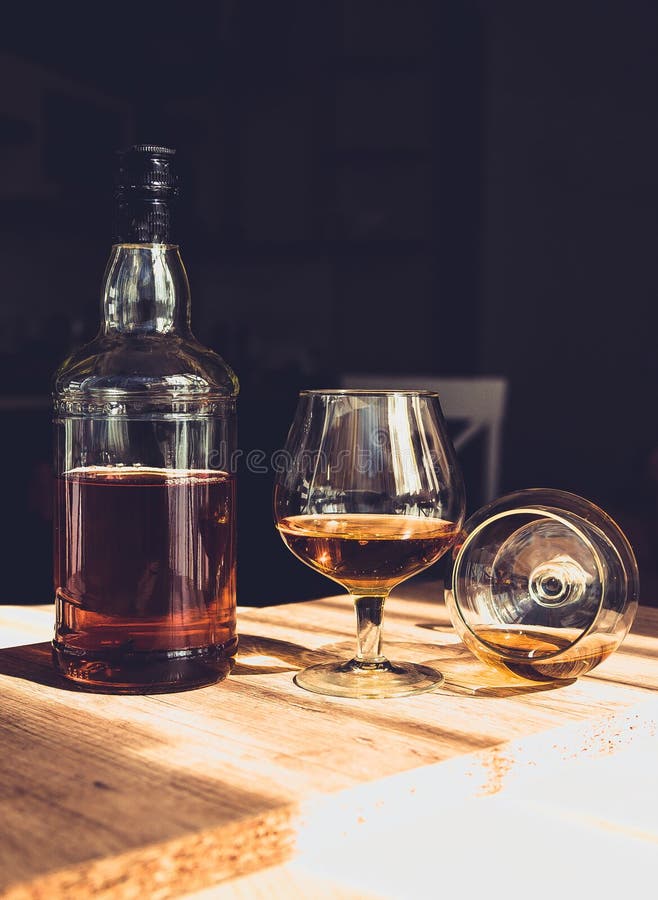 Bottle of Brandy and Two Glasses of Alcohol in a Bar Stock Image