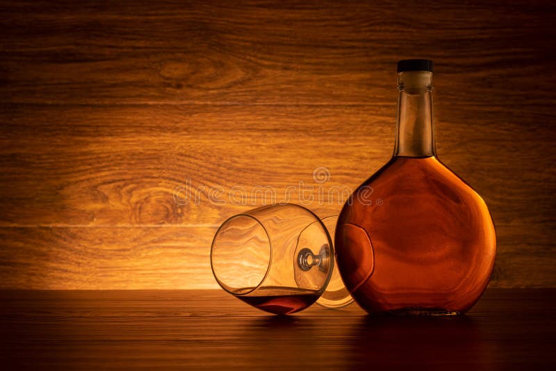 Bottle of Brandy with Wine Glass on Wooden Background Stock Image